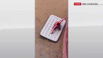 Alluvione Ibiza, uomo naviga strade allagate su materassino