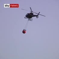 Helicopter drops water on burning moor