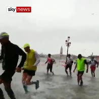 Venice marathon runners splash through street
