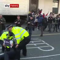 Protester blocks van driving away Assange