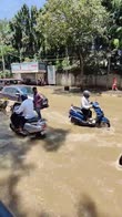 India, pendolari vanno a lavoro in moto su strada allagata